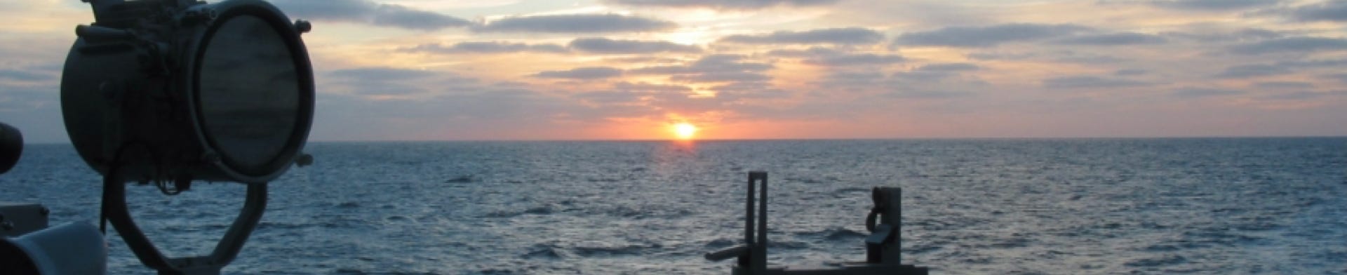Foto van een zonsondergang op zee, genomen vanaf de brugvleugel van een Multipurpose Fregat (M-FF).